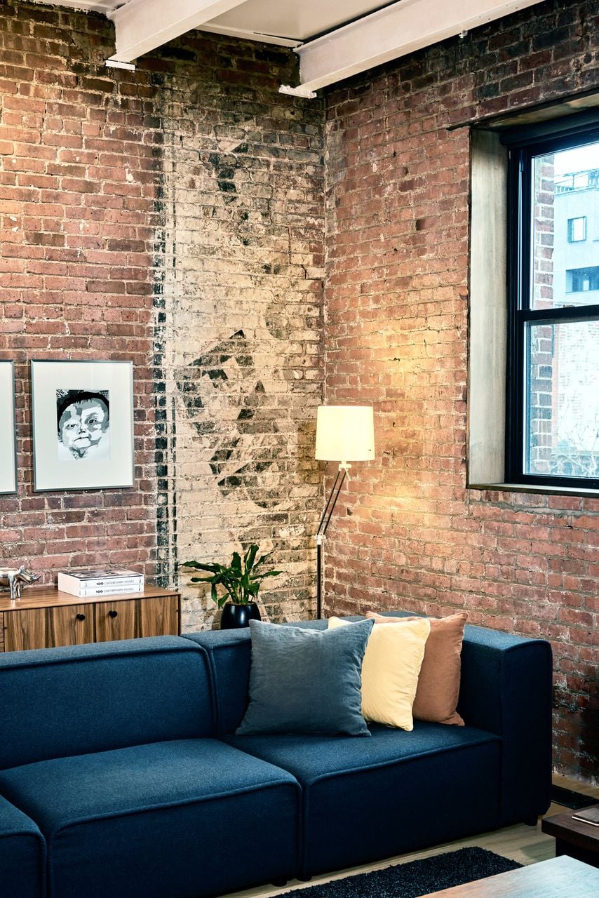 In certain parts of the loft, as is in this corner, OSSO chose to leave the old paper factory's original brickwork exposed for aesthetic effect.