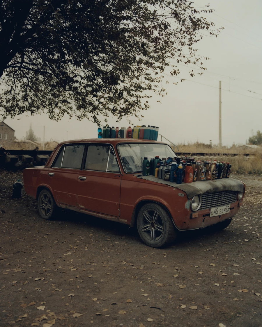 Bottles of various liquids stacked on top of a Soviet-era Lada car in Armenia.