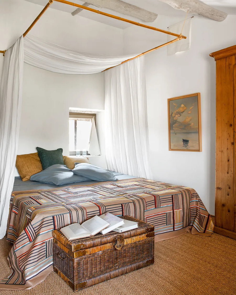Light, simple bedroom area in the Pierre Frey countryside home filled with imaginative textiles. 