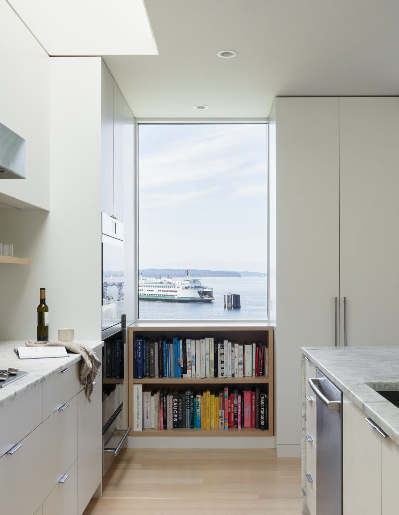 View out at a ship on the Puget Sound from the Fauntleroy home's minimalist white kitchen space.