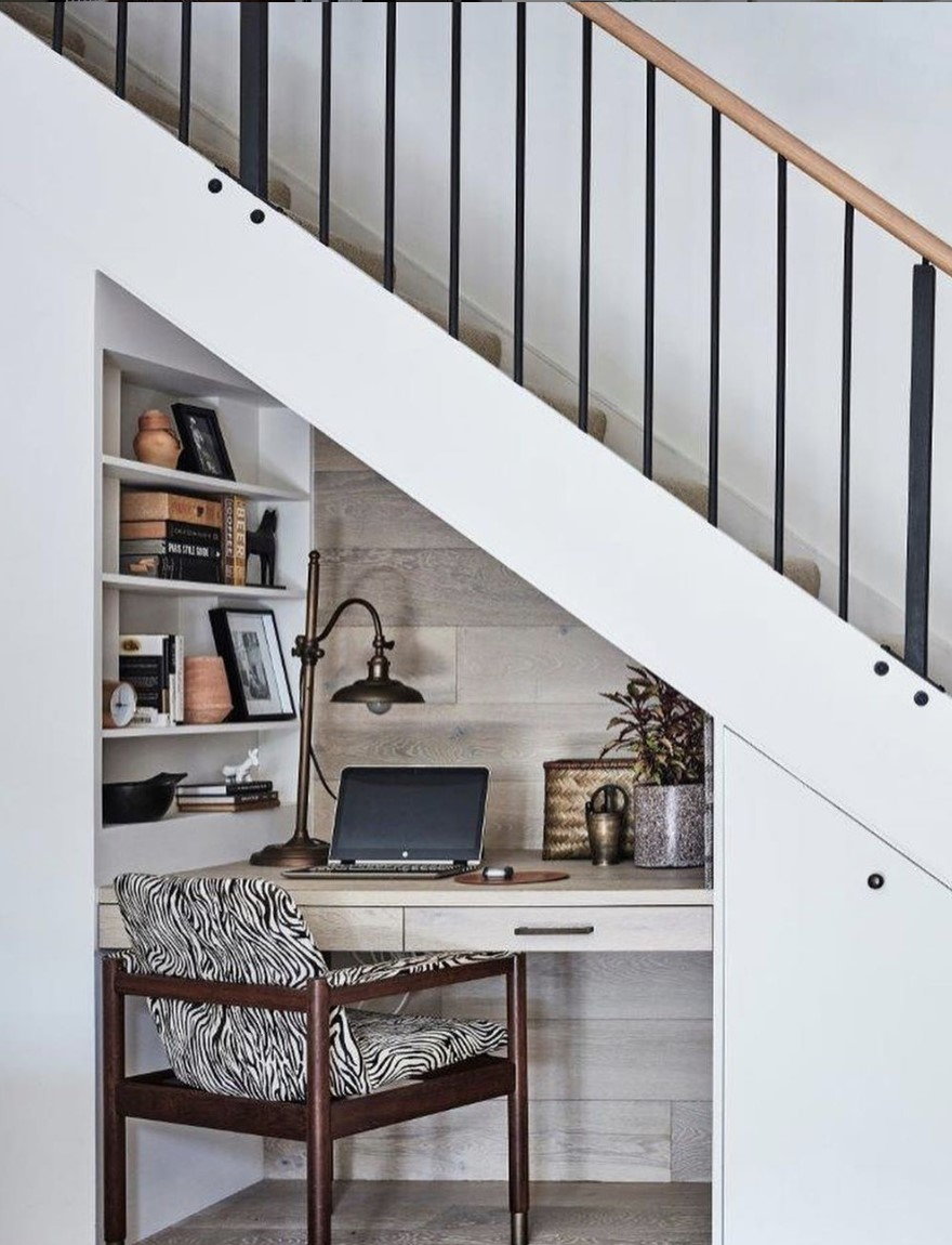 Cozy Under-Stair Workspace, compelte with a small desk and built-in shelving for storage.