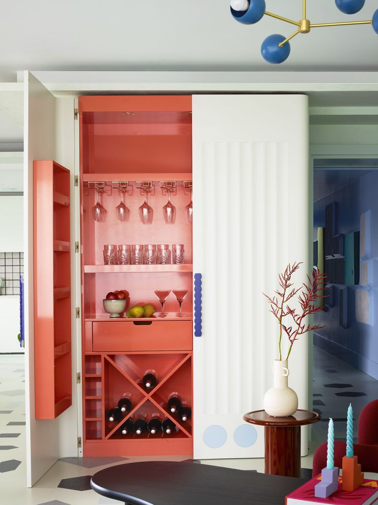 Striking red bar cabinet inside Owl Interior Design's Bowie-inspired London apartment. 