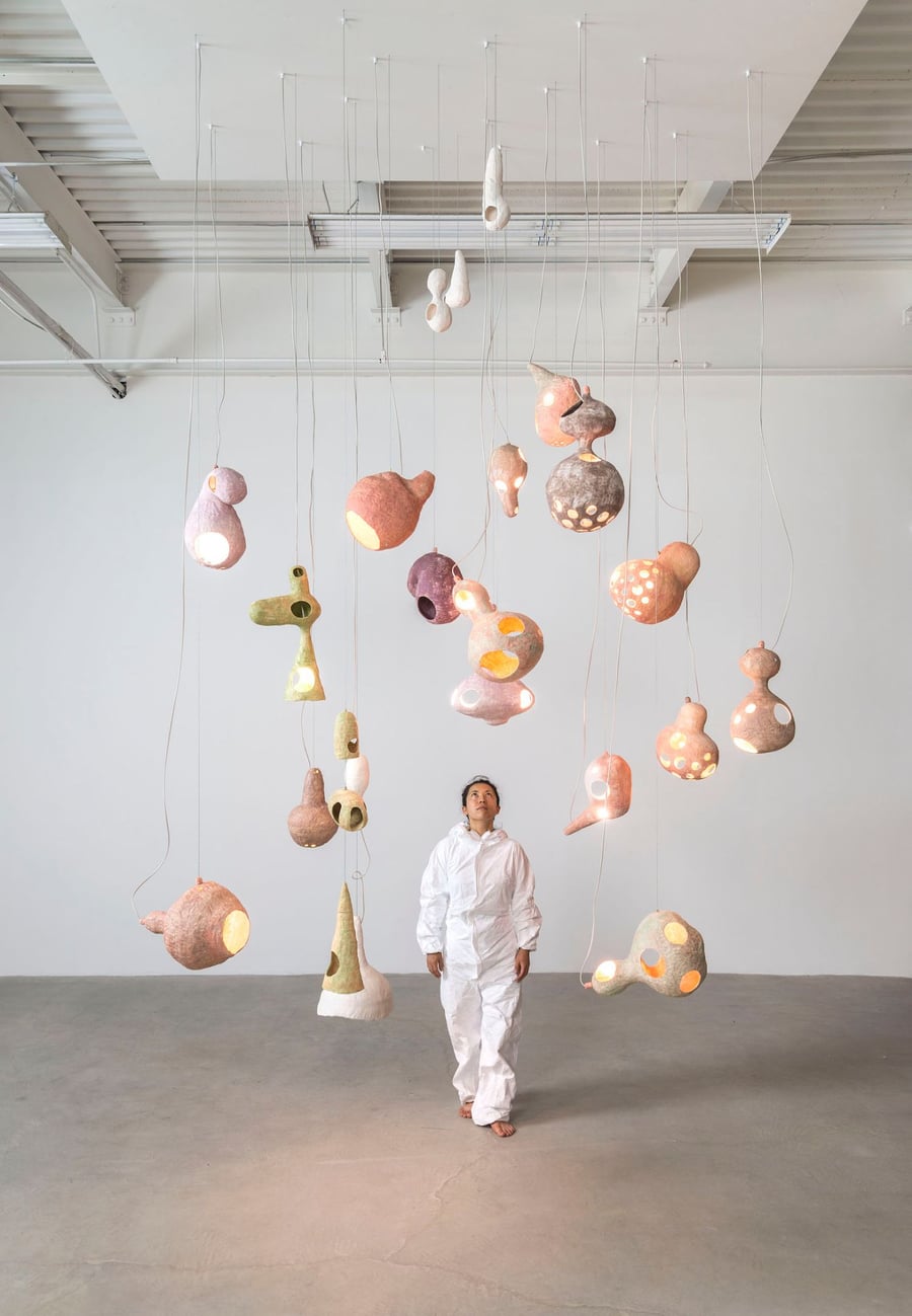 Designer Yuko Nishikawa stands among her handcrafted organic lighting fixtures. 