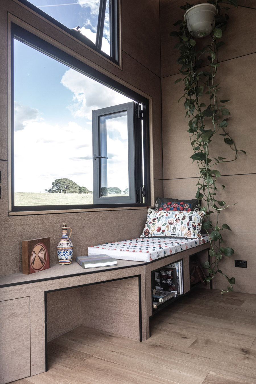 The inside of the Base Cabin is simple and cozy, featuring a welcoming window seat and lots of plywood. 
