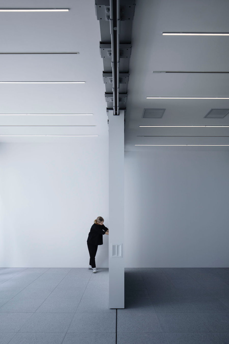 Person pushes one of the Gallery COMMON's four movable walls to quickly change the space's layout.