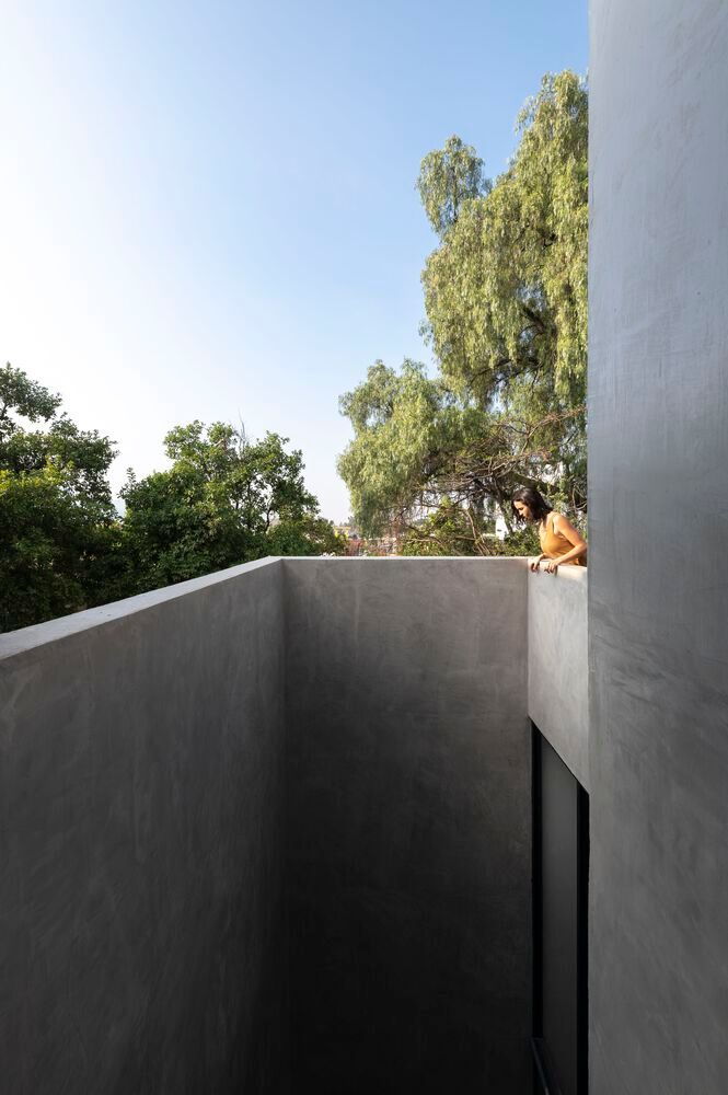 Woman looks down into a courtyard space from the rooftop of Espacio 18's 
