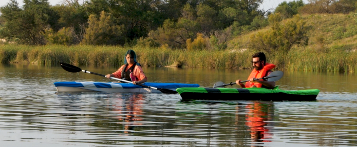 A couple sails through calm waters on their ultra-lightweight Pontos packable kayaks. 