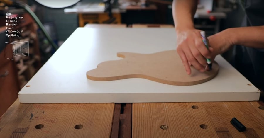 Youtube user Tchiks Guitars traces the body shape of an electric guitar onto an old piece of IKEA wood. 