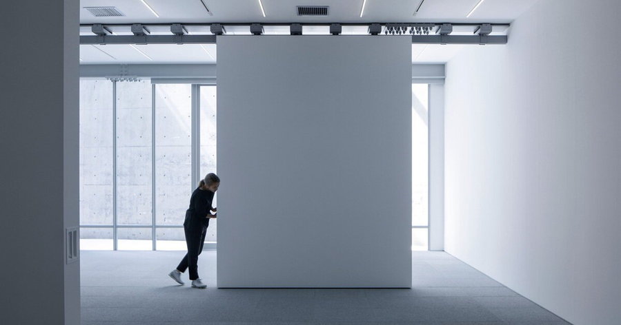 Side view of person pushing a Gallery COMMON movable wall to quickly change the space's layout.