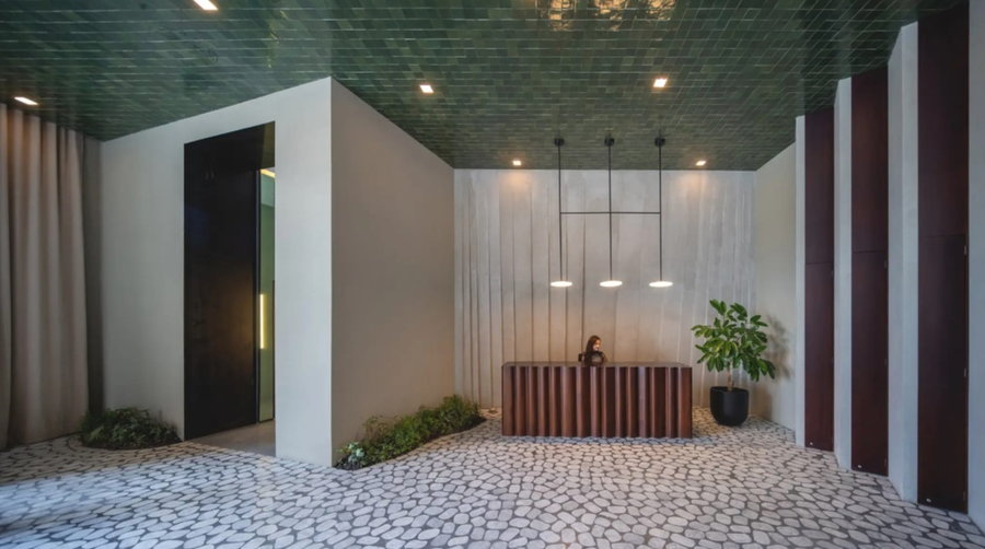 The main lobby of the IQON building boasts an emerald green ceiling and calming tiled floors that offer a nice contrast to the building's angular exterior.
