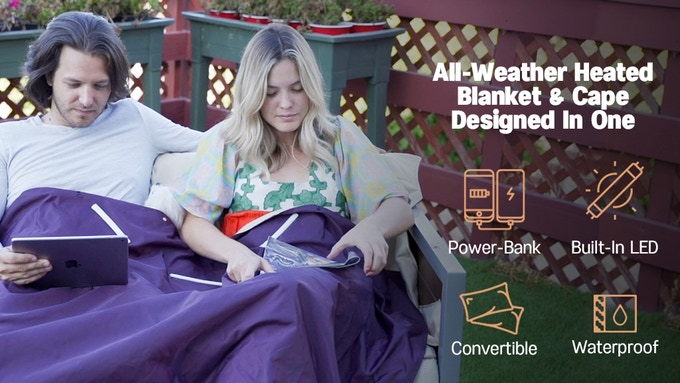 Couple enjoys reading outside beneath the comfort and warmth of their V-Blanket 
