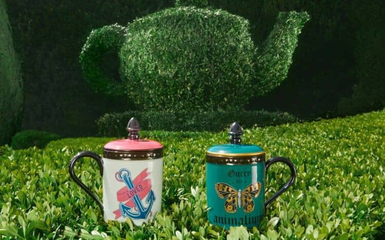 Colorful print mugs from the Gucci Décor in a garden setting. 