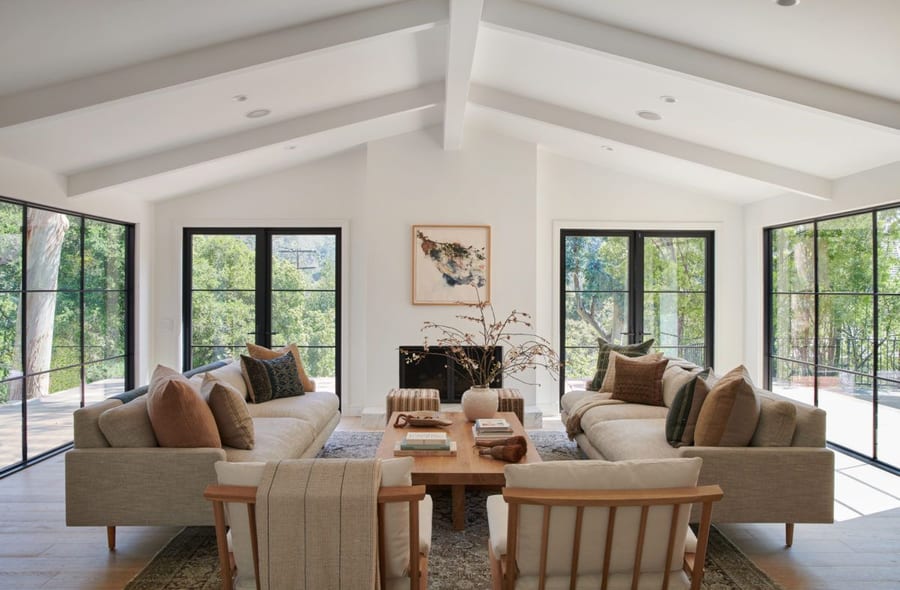 Beige couches, large windows, and lots of white wall space define this California Cool living area. 