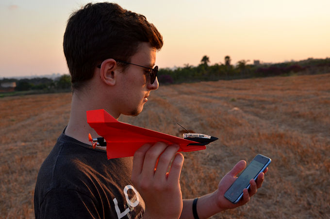 Young man uses his phone to control his high-tech POWERUP paper airplane