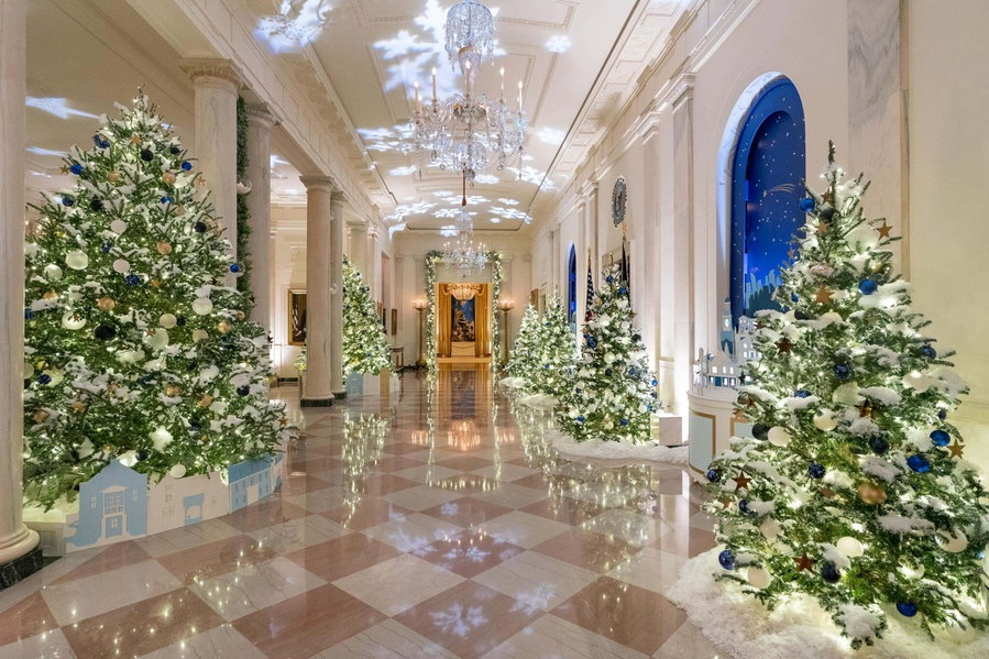 Large Christmas trees and elegant ornaments adorn the White House's Grand Foyer area in 2021.