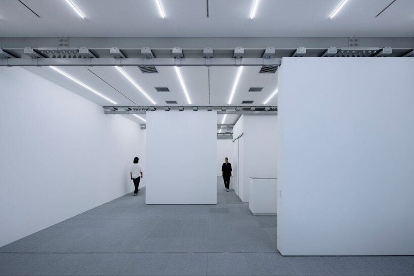 Patrons roam the all-white interiors of the Gallery COMMON basement exhibition space.