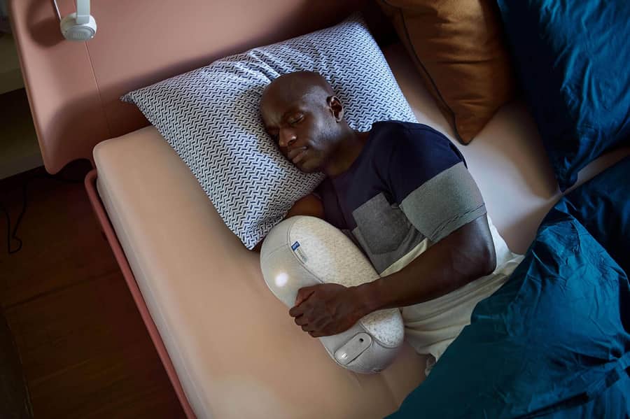 Man sleeps soundly as he cuddles with his Somnox robotic pillow