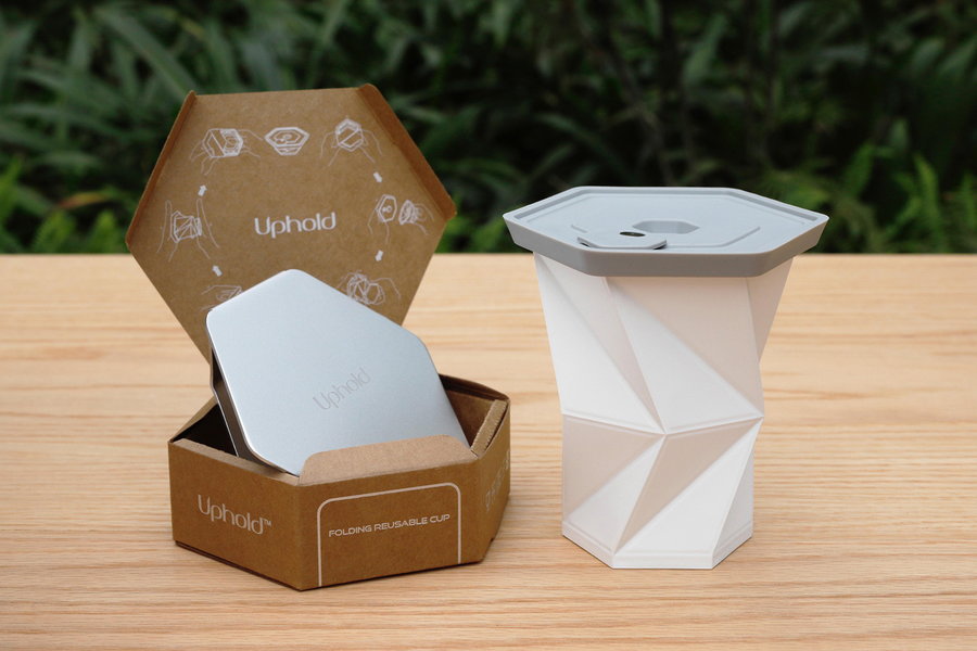 An unfolded Uphold Cup next to a fully folded one still in the packaging. 