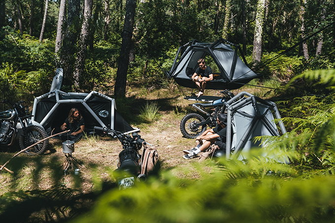 Group of friends camps out in a forest setting, each with their own ARK shelter set up. 