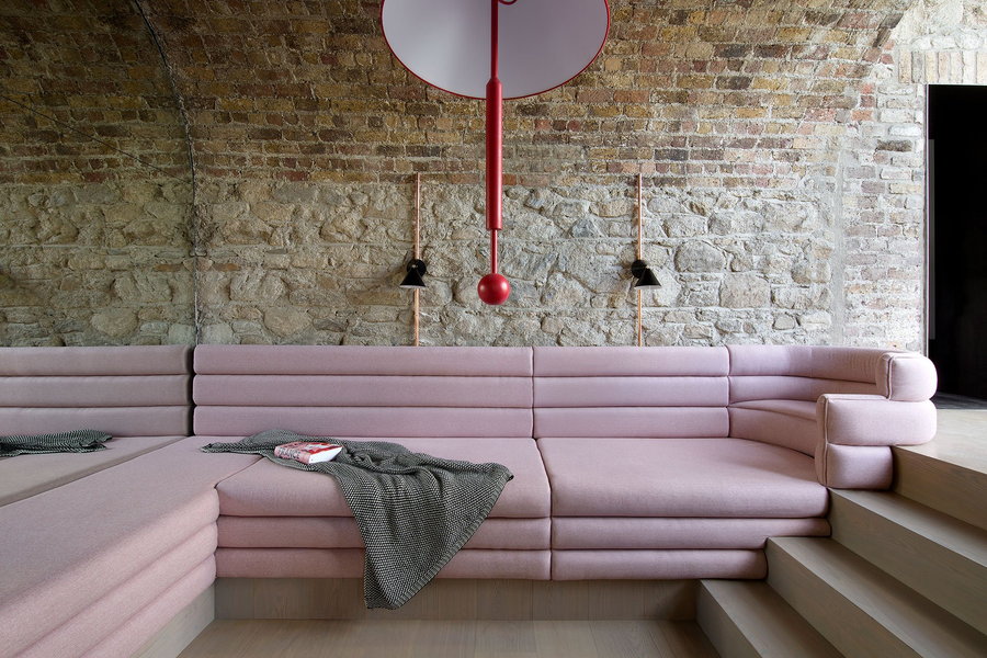 A large custom-made pink couch graces the inside of the renovated Bolton Carriage House.