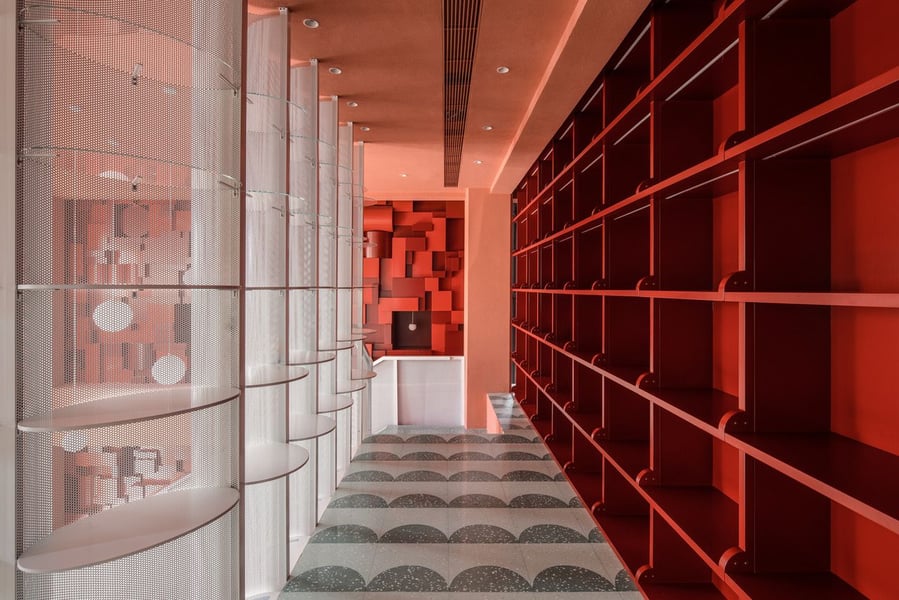 Striking red bookshelves and patterned floors complement the built-in writing stations on the Bund Post Office's second floor