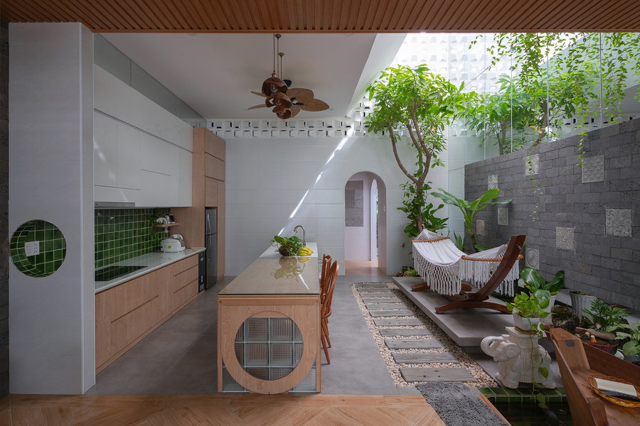 Simple open plan kitchen inside the Coco House contains more greenery and lots of neutral tones.