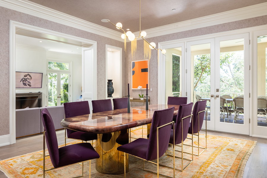 Modern dining space in Katy Perry's Beverly Hills home uses rich purple dining chairs to draw the eye in.