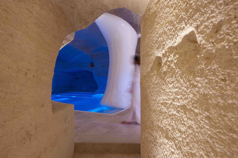 Cave-like entrance to the Aquatio Hotel and Spa's indoor pool glows a welcoming blue light. 
