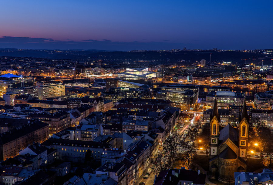 Nighttime aerial view shows how BIG's Vltava Philharmonic Hall design fits into the surrounding cityscape.