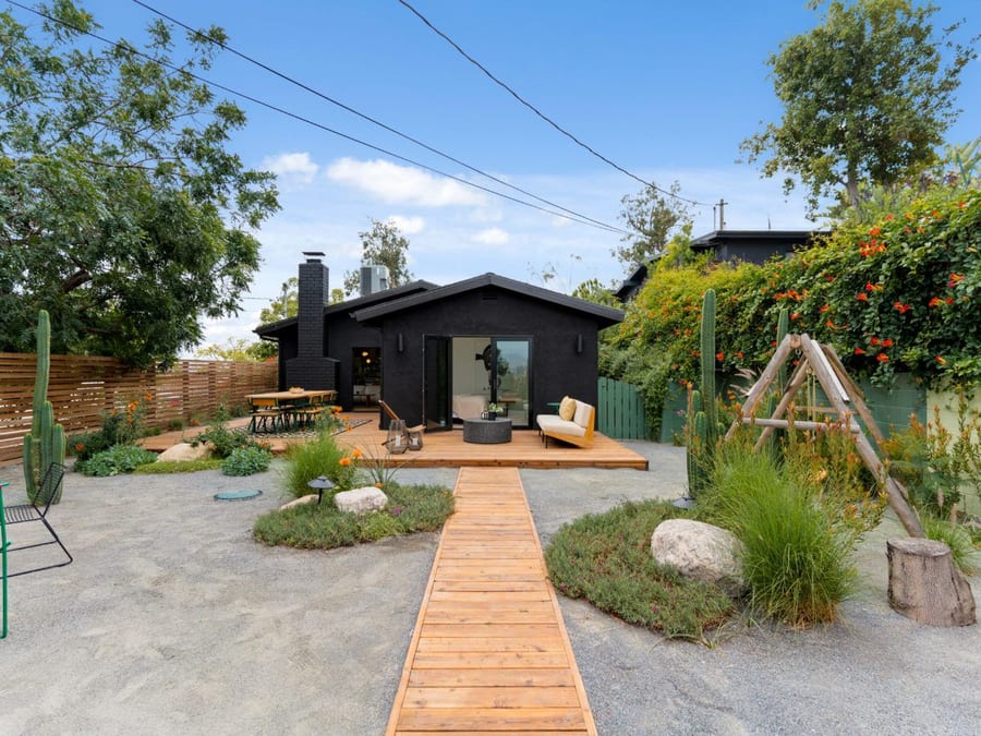 Los Angeles landscape project by Sarita Jaccard features area-appropriate plant life, wooden walkways, and plenty of pebbles.