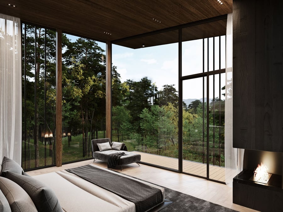 A luxurious master bedroom in the Sylvan Rock home looks out over tranquil New York wilderness.