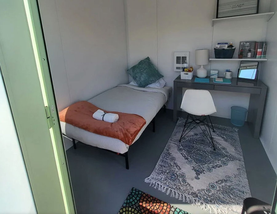 Small, personalized bedroom inside DignityMoves' San Francisco tiny homes for the homeless. 