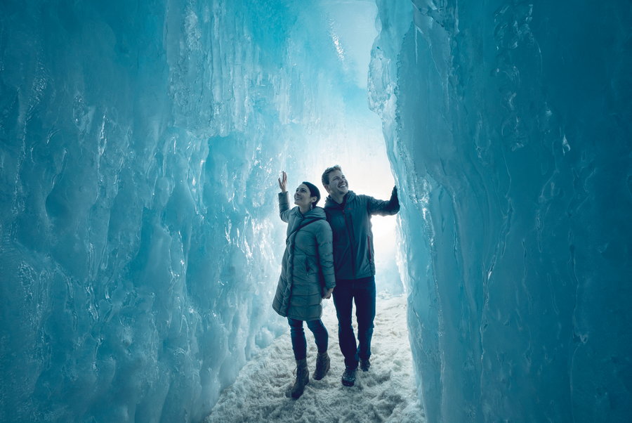 Young couple wanders the crystalline walls of one of Brent Christensen's ice castles.