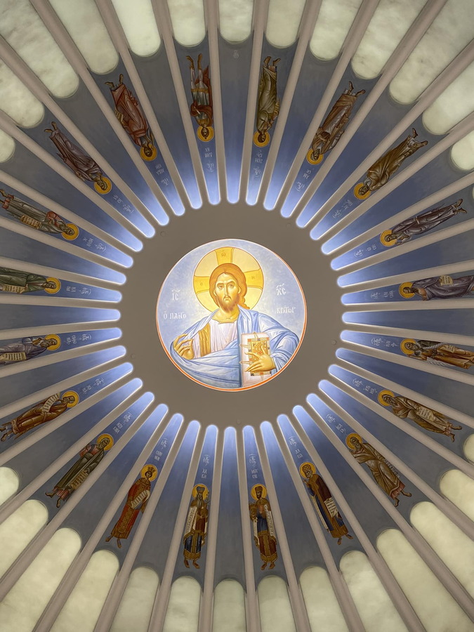 A glass painting of Christ appears at the center of the restored church's dome ceiling.