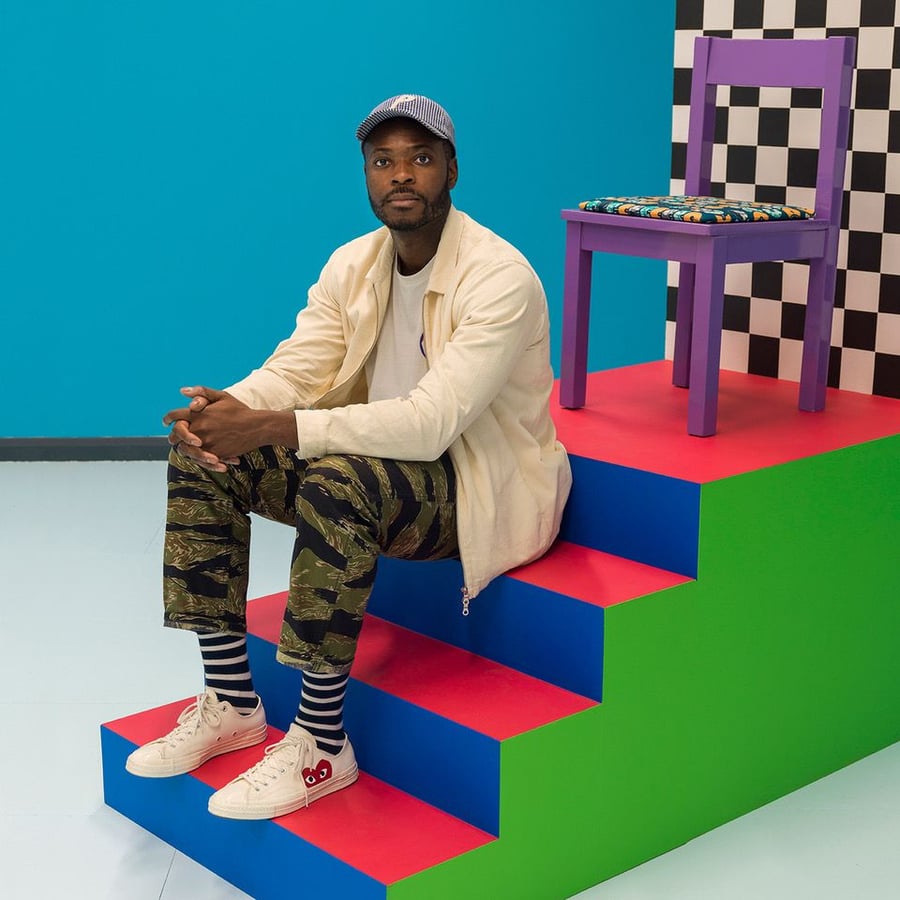 Artist Yinka Ilori poses atop a set of steps in his brightly-colored Colorama Skatepark.
