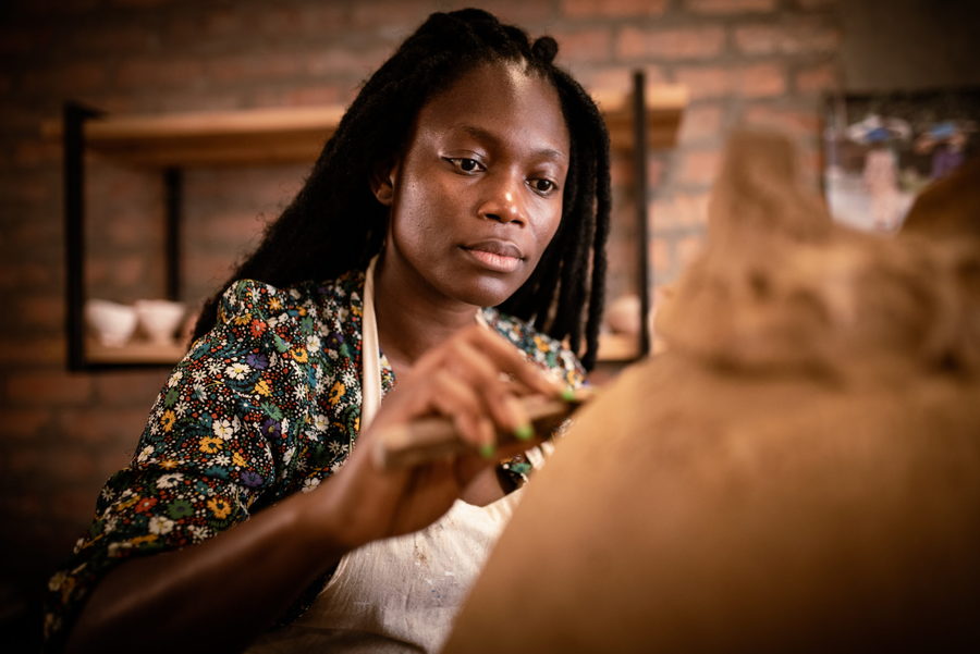 South African artist Zizipho Poswa hard at work on a clay sculpture. 