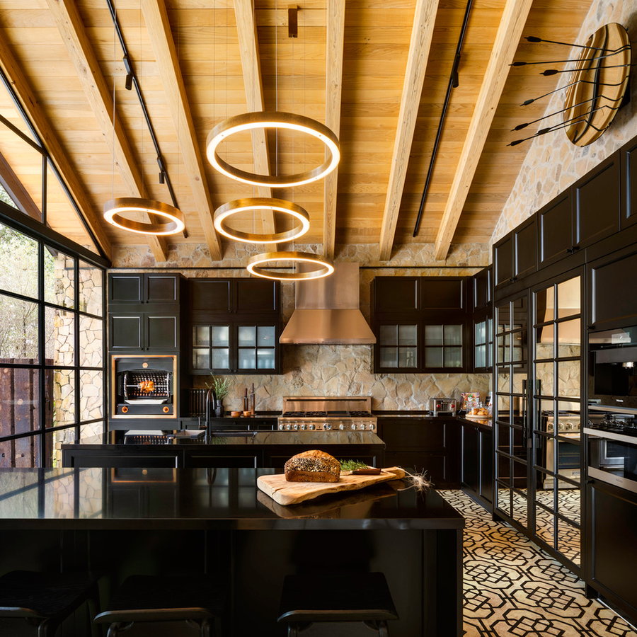 Black modern kitchen space inside Casa Rancha Avándaro, complete with circular lighting fixtures.