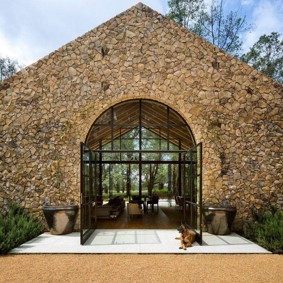 German shepherd sits on the expansive glass entrance to the Casa Rancha Avándaro's living area. 