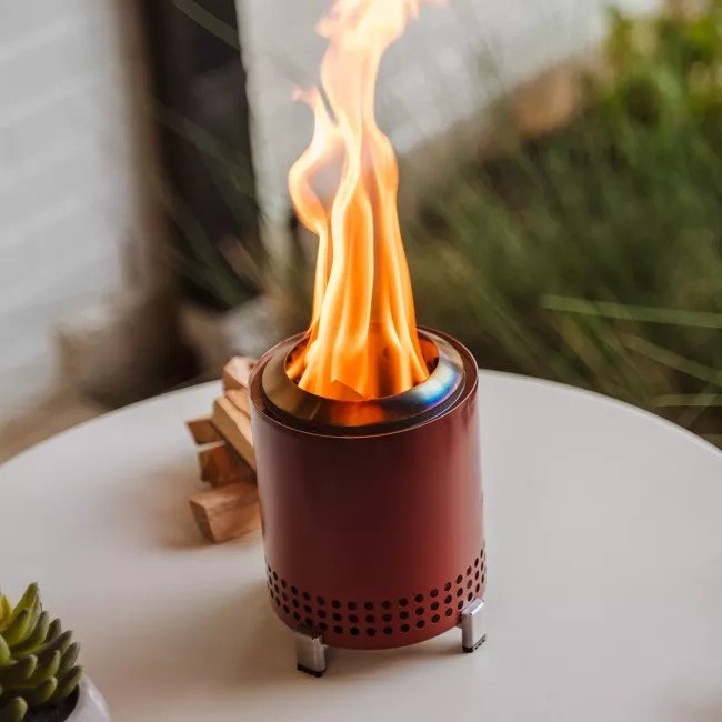 Mesa Tabletop Fire Pit from Solo Stove burns brightly on a small outdoor table.