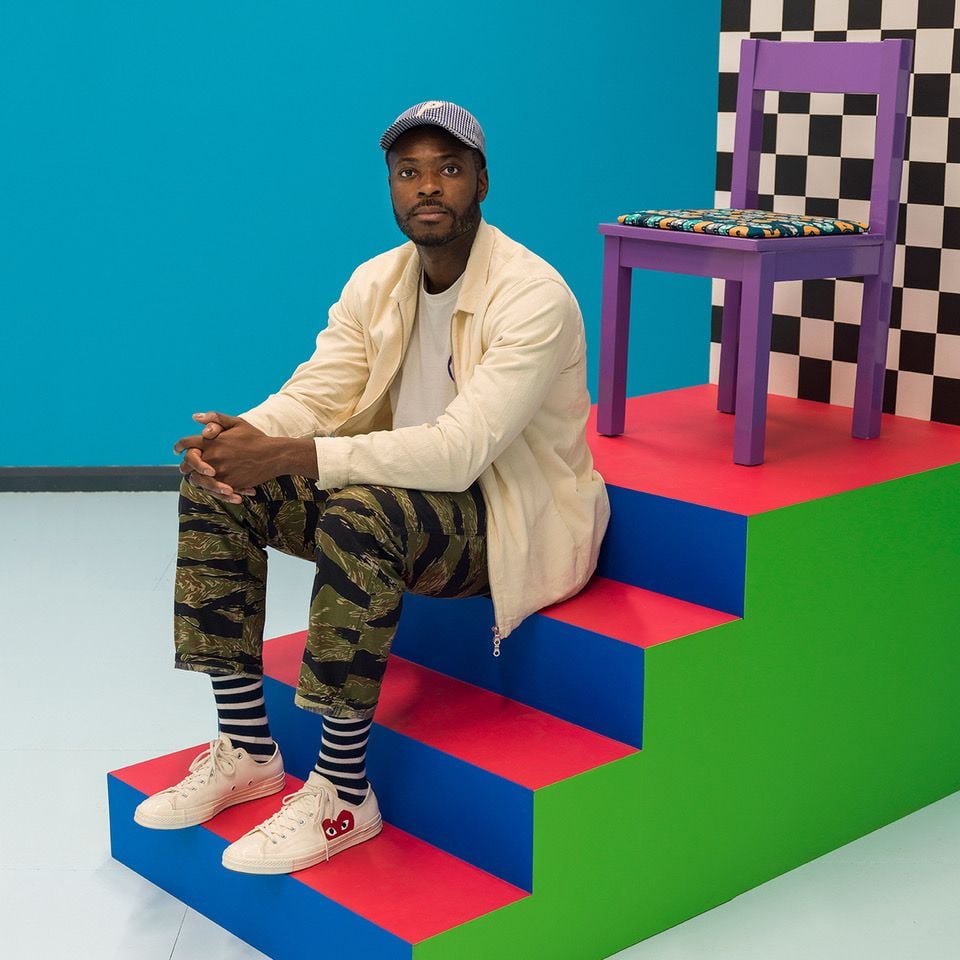 Artist Yinka Ilori poses atop a set of steps in his brightly-colored Colorama Skatepark.