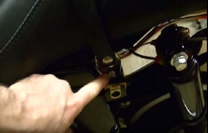 Use a 7/16" socket to remove the seat strap