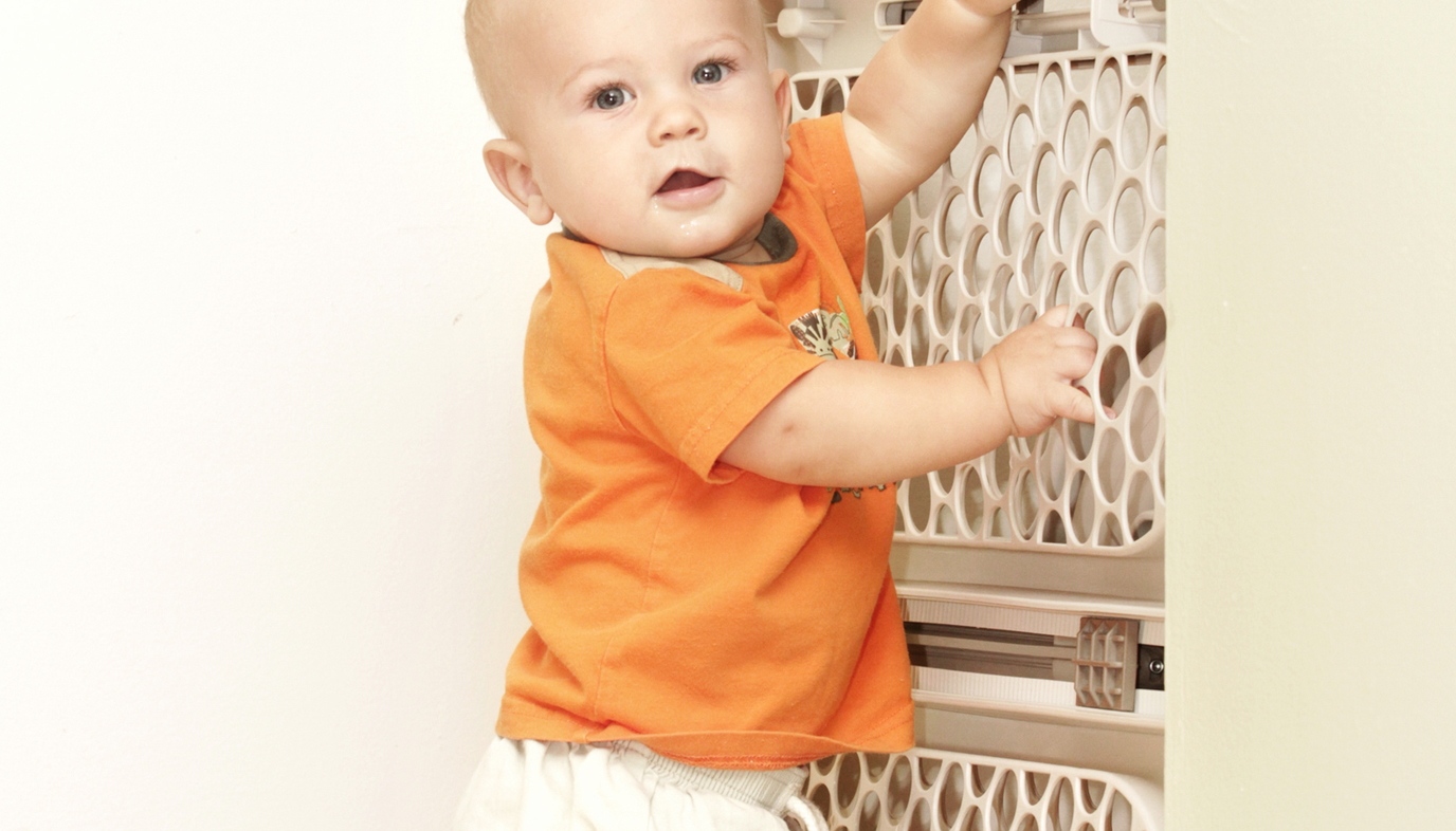 baby standing by baby gate