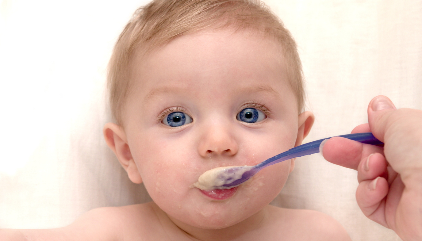 mom feeding baby cereal from a spoon