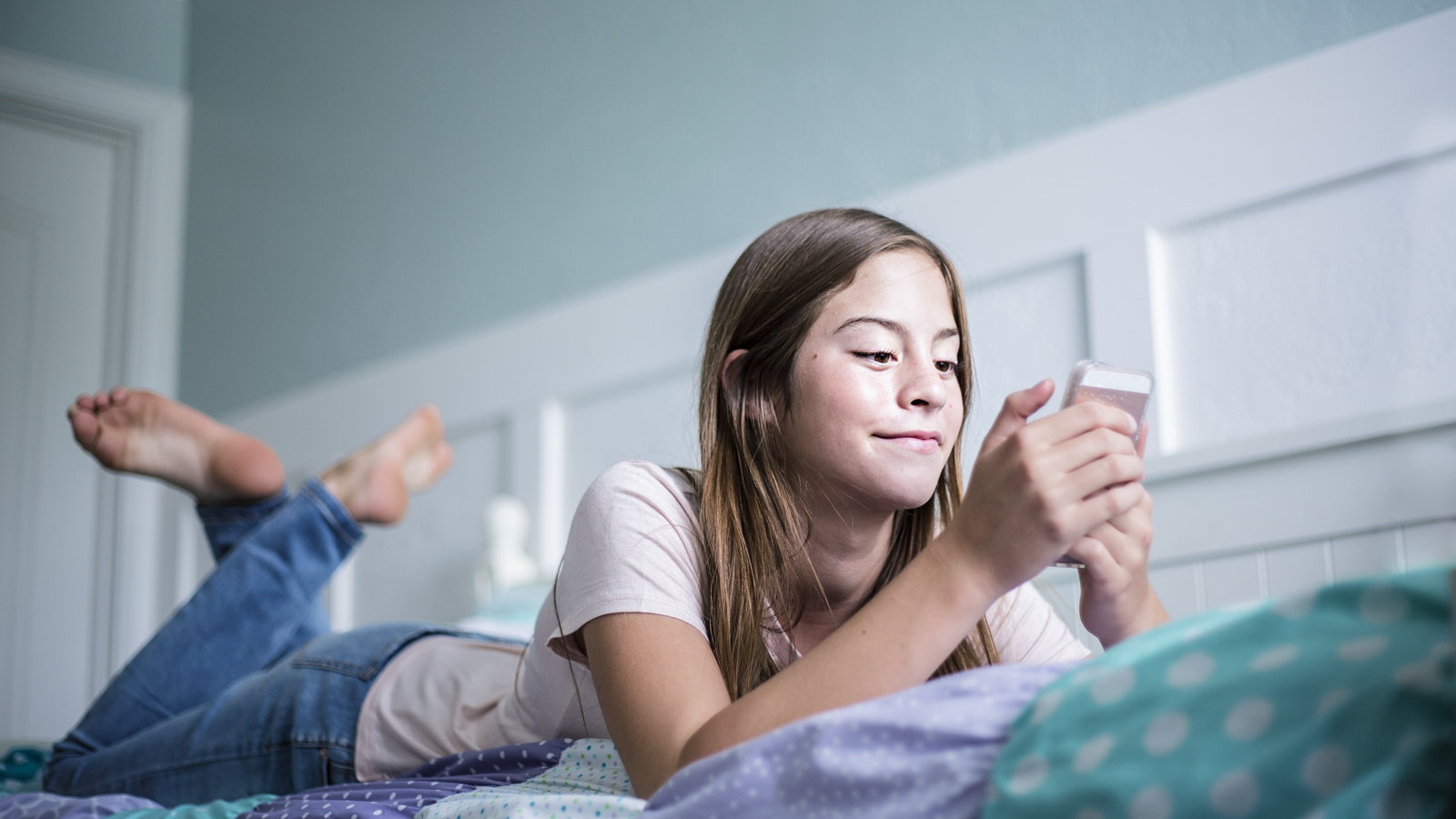 daughter using phone in bedroom