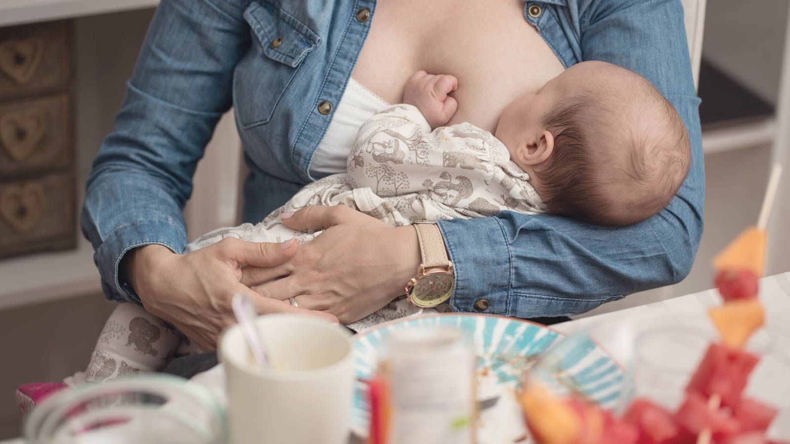 woman breastfeeding at dinner table