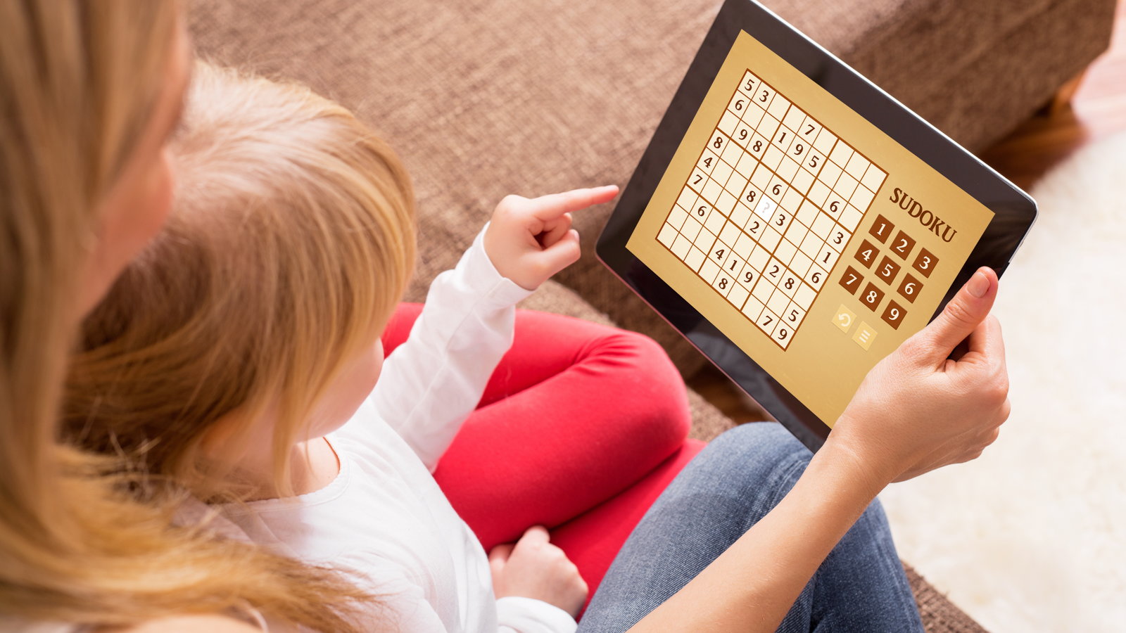 mom and child playing education game on tablet