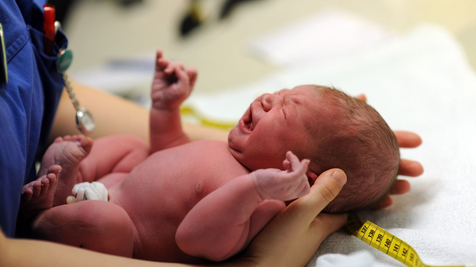 newborn being measured after birth