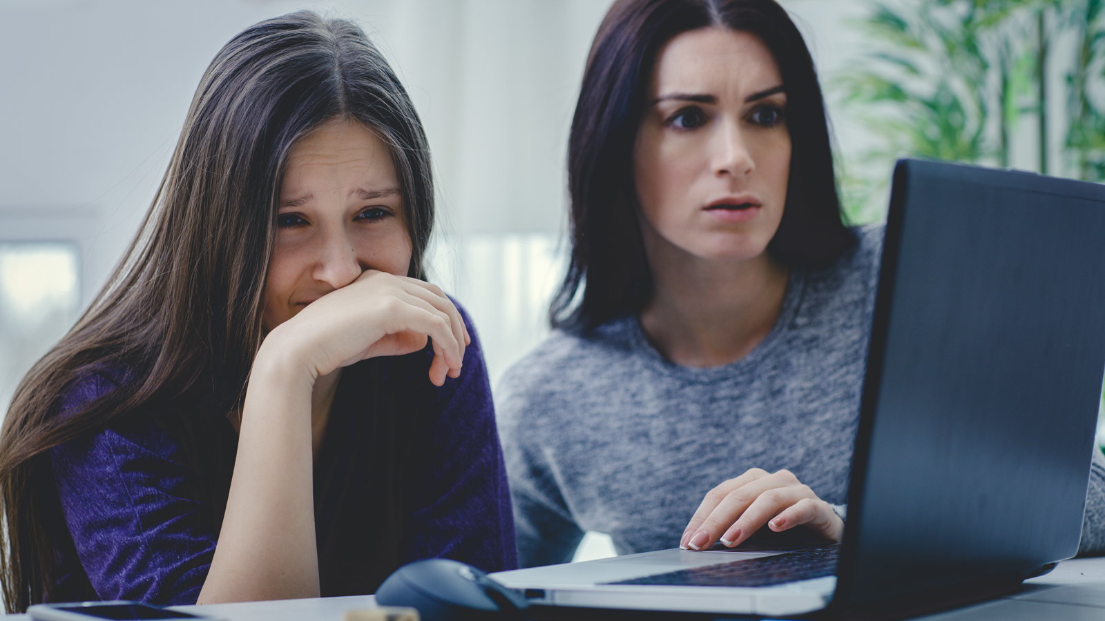 mother and daughter upset looking at laptop