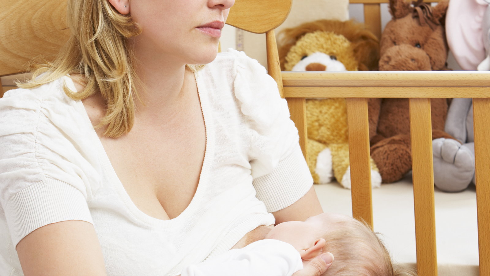 sad woman breastfeeding in rocking chair