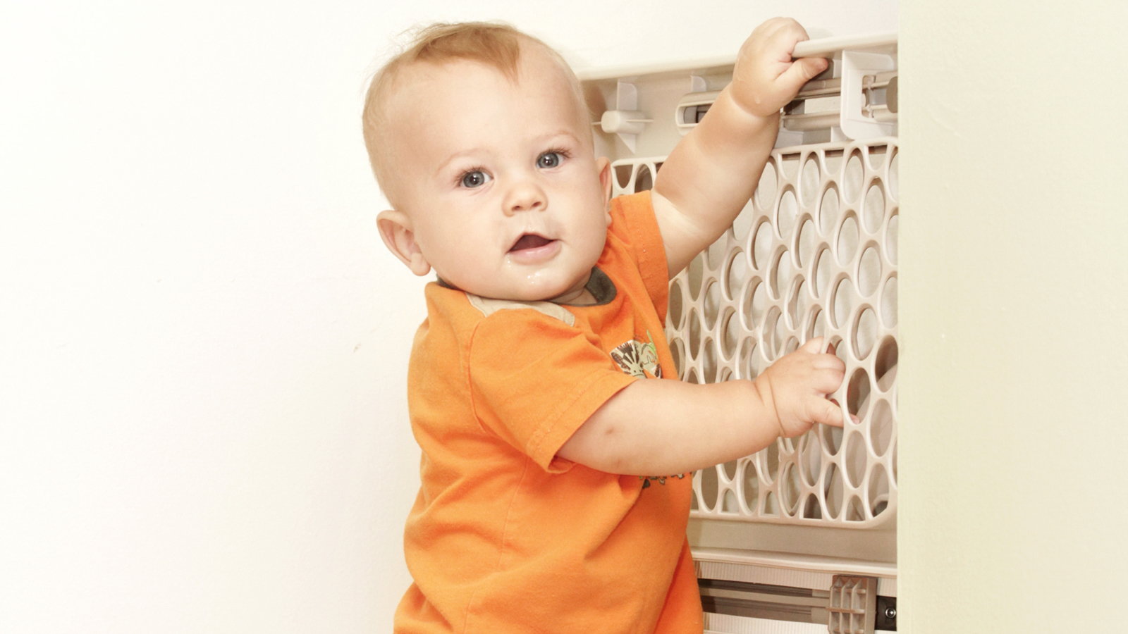baby holding onto baby gate